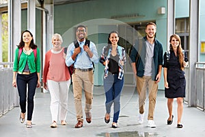 A group of happy teachers walking in a school corridor photo