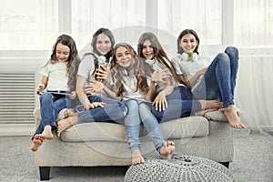 Group of happy teenage girls with gadgets. Social networks, friendship, technology and children concept.