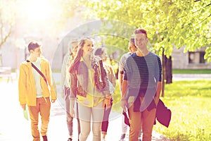 Group of happy teenage students walking outdoors
