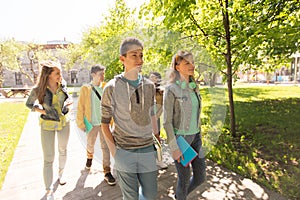 Group of happy teenage students walking outdoors