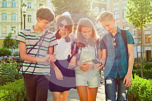 Group of happy teenagers friends 13, 14 years walking along the city street.