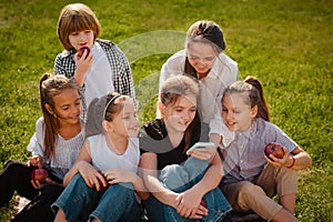 Group of happy teenagers laughing outdoors. children spend time with gadgets outdoors