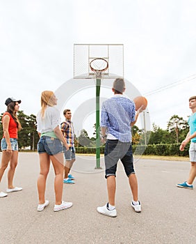 Group of happy teenagers playing basketball