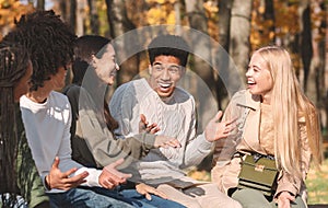 Group of happy teenagers talking and laughing in park