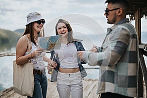 Group of happy tourists with a map enjoying their holiday by the lake