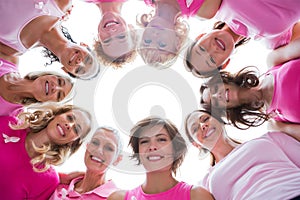 Group of happy women in circle wearing pink for breast cancer