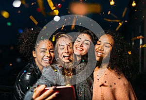 Group of happy women taking selfie on mobile phone