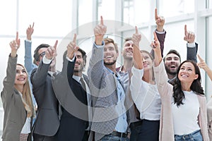 Group of happy young business people pointing upwards