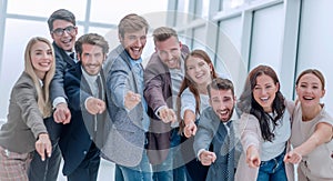 Group of happy young business people pointing at you