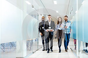 Group of happy young business people walking in office together photo