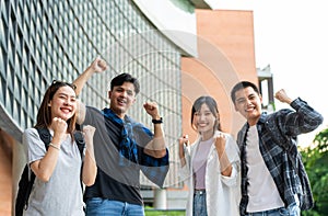 Group of happy young entrepreneurs with hands up and laughing to celebrate and excited success for achievements obtained.