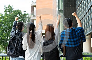 Group of happy young entrepreneurs with hands up and laughing to celebrate and excited success for achievements obtained.