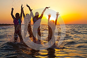Group of happy young girls jumping at the beach