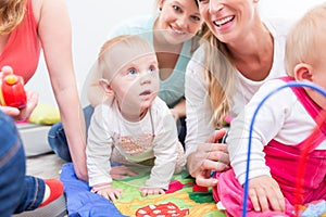 Group of happy young mothers watching their cute and healthy babies