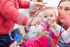 Group of happy young mothers watching their cute and healthy babies play