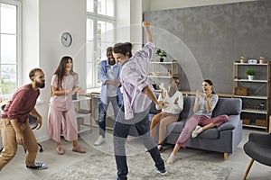 Group of happy young multiethnic friends dancing and having fun at a party at home