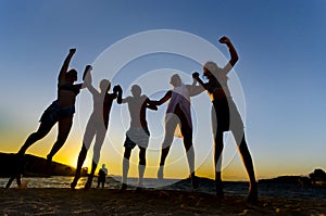 Group of happy young people dancing at the beach