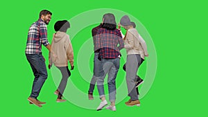 Group of happy young people dancing together on a Green Screen, Chroma Key.