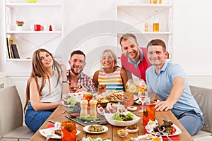 Group of happy young people at dinner table, friends party