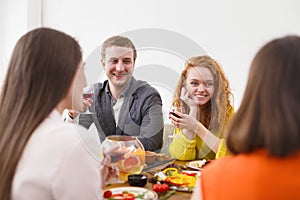 Group of happy young people at dinner table, friends party