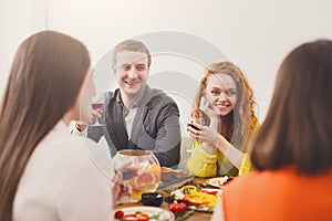 Group of happy young people at dinner table, friends party