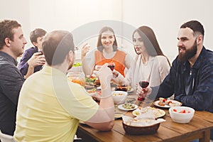 Group of happy young people at dinner table, friends party