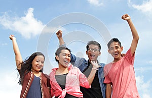 Group of happy young people with hands up