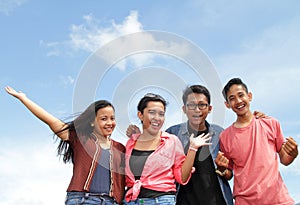 Group of happy young people with hands up and cheers