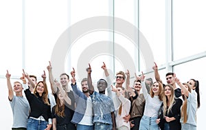 Group of happy young people pointing upwards