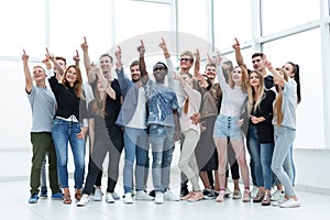 group of happy young people pointing upwards