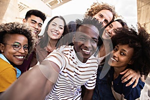 Group of happy young people taking selfie portrait together outdoor