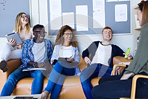 Group of happy young students speaking in a university.