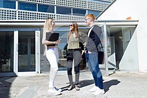 Group of happy young students speaking in a university.