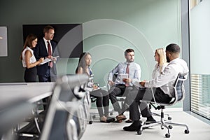 Group Having Discussion At Graduate Recruitment Assessment Day Whilst Being Observed By Recruitment Team photo