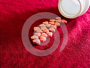 Group of hearts pills in red cloth background. Valentines day