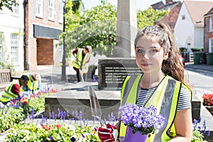 Group Of Helpful Teenagers Planting And Tidying Communal Flower