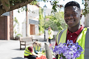 Group Of Helpful Teenagers Planting And Tidying Communal Flower