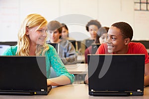 Group Of High School Students In Class Using Laptops