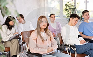 Group of high school students listening to lecture in auditorium