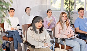 Group of high school students listening to lecture in auditorium