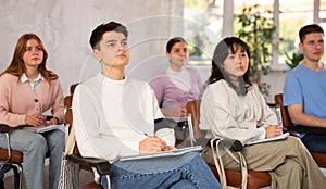 Group of high school students listening to lecture in auditorium