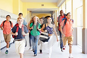 Gruppo da alto studenti correre lungo corridoio 