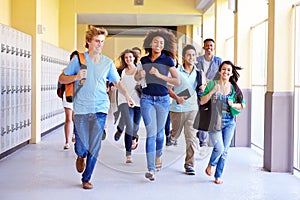 Group Of High School Students Running In Corridor