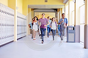 Group Of High School Students Running In Corridor