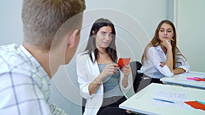 Group of high school students sitting in classroom and having conversation practice