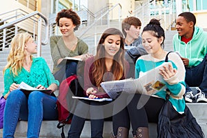 Group Of High School Students Sitting Outside Building