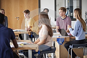 Group Of High School Students Sitting At Work Benches Having Discussion In Design And Technology Lesson