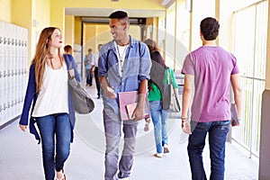 Group Of High School Students Walking Along Hallway