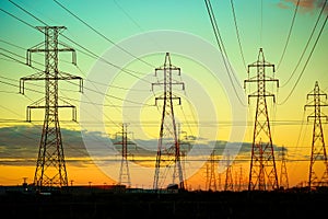 Group of high-voltage electricity power pylons during sunset
