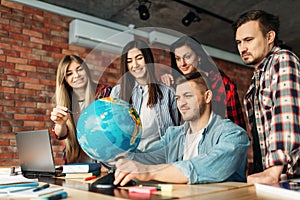 Group of highschool students looking at the globe